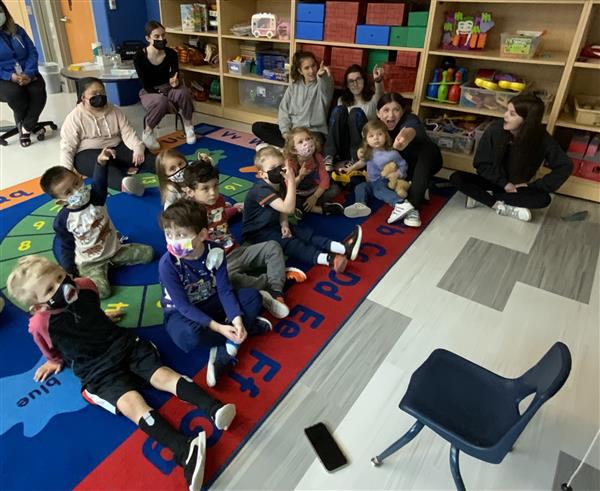 Children sitting on rug learning at circle time.